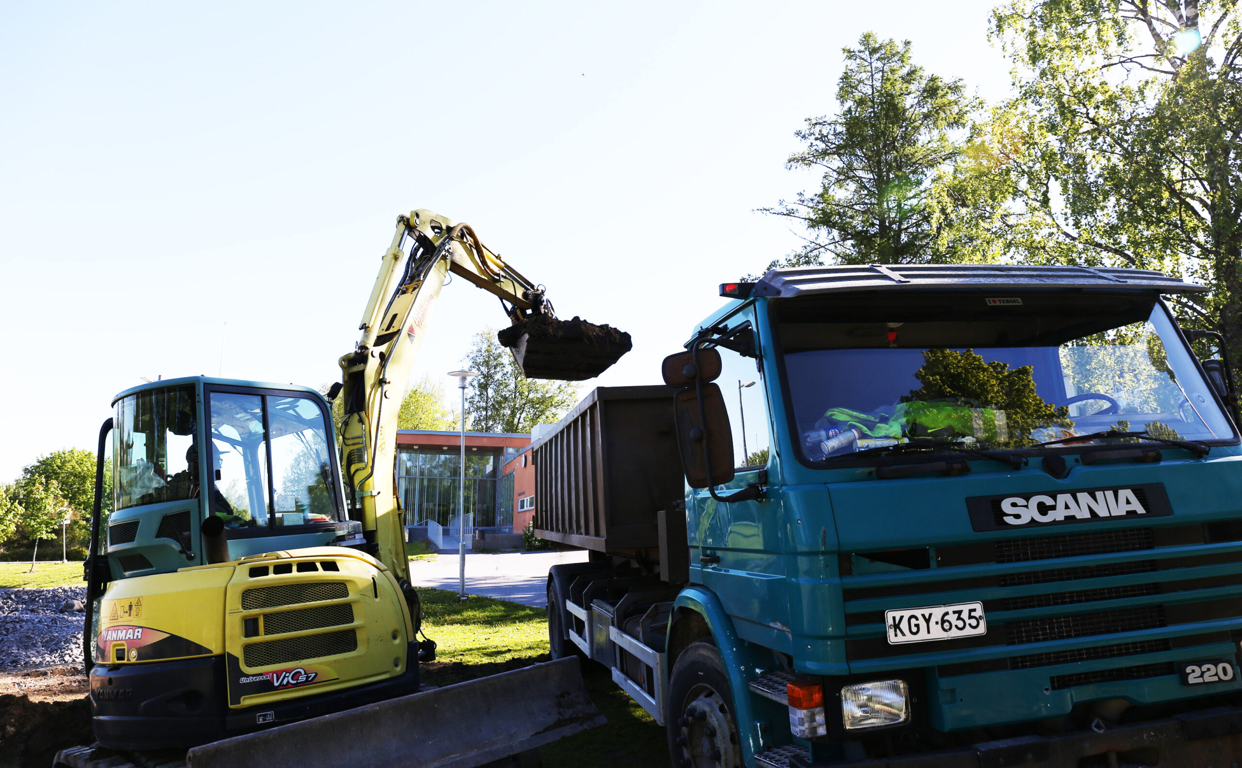Yrityksen kaivinkone ja kuorma-auto työmaalla